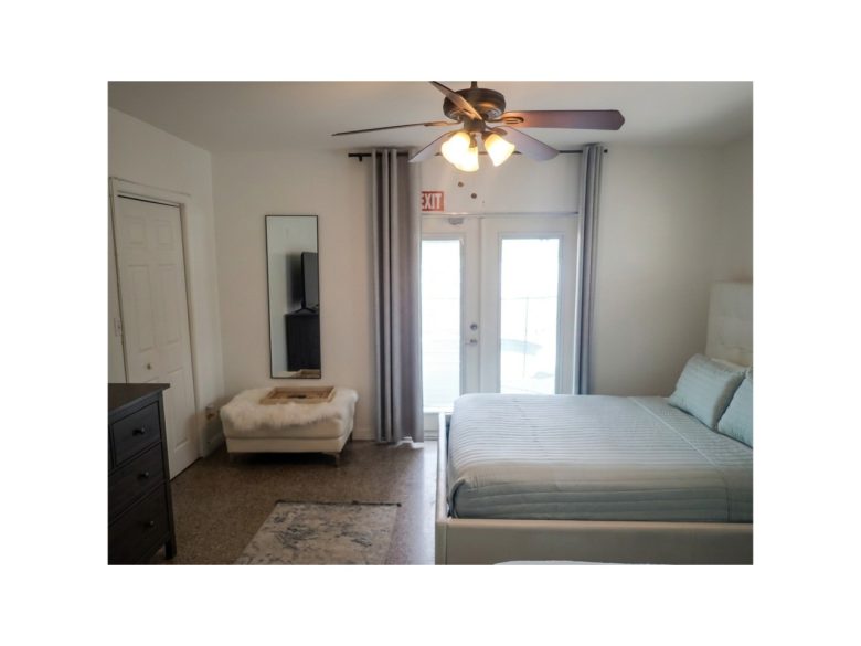 Another view of the master bedroom's queen bed with direct access to the pool.