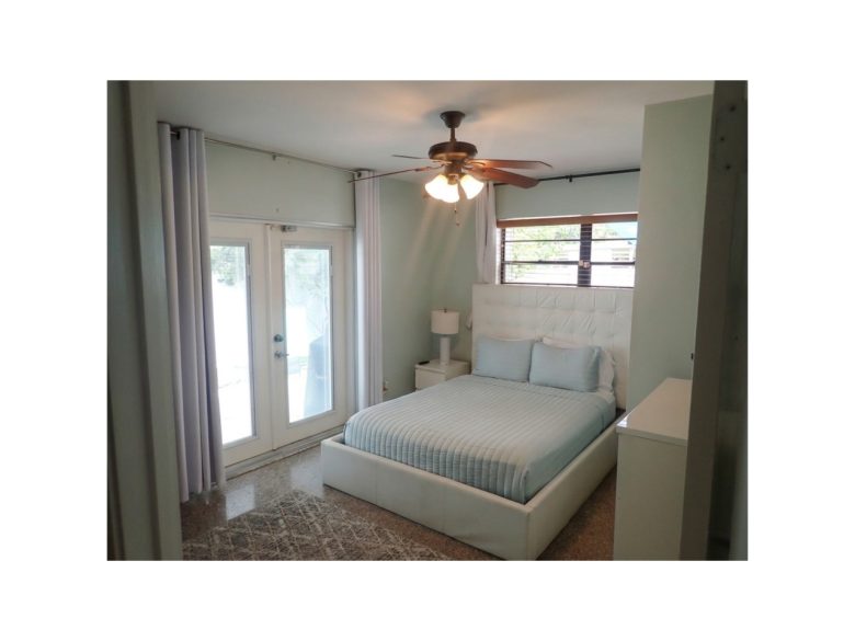 Guest bedroom with queen bed and access to the pool